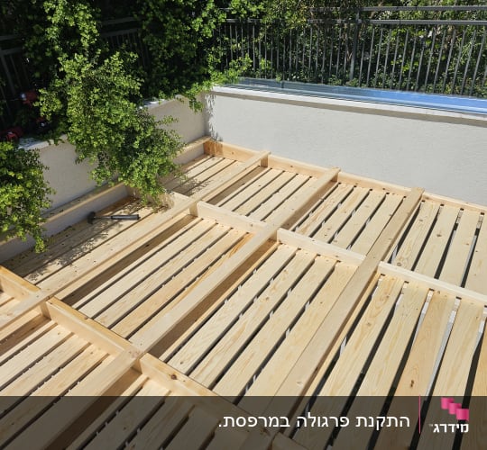 עבודת עץ בגינה עם לוחות עץ ומסגרת